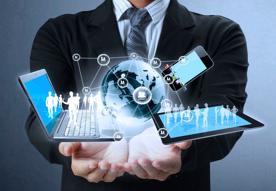 An image of hands with floating world with connected laptop, phone, tablet and people.